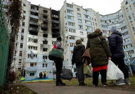 Vecinos de Kiev observan un edificio en el que ha impactado un dron ruso.