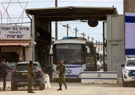 Miembros de las fuerzas de seguridad israelíes vigilan a los autobuses que transportan a presos palestinos liberados.