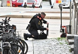 Un agente del escuadrón antibombas analiza un artefacto en una calle de Estocolmo.