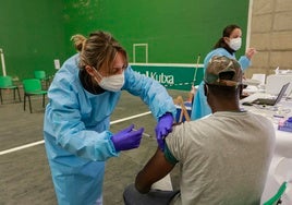 Una sanitaria inyecta a un ciudadano la vacuna contra la covid durante la pandemia.