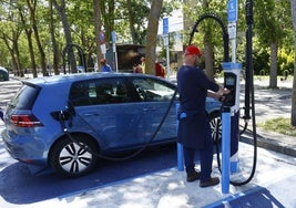 Un conductor cargando un vehículo eléctrico.