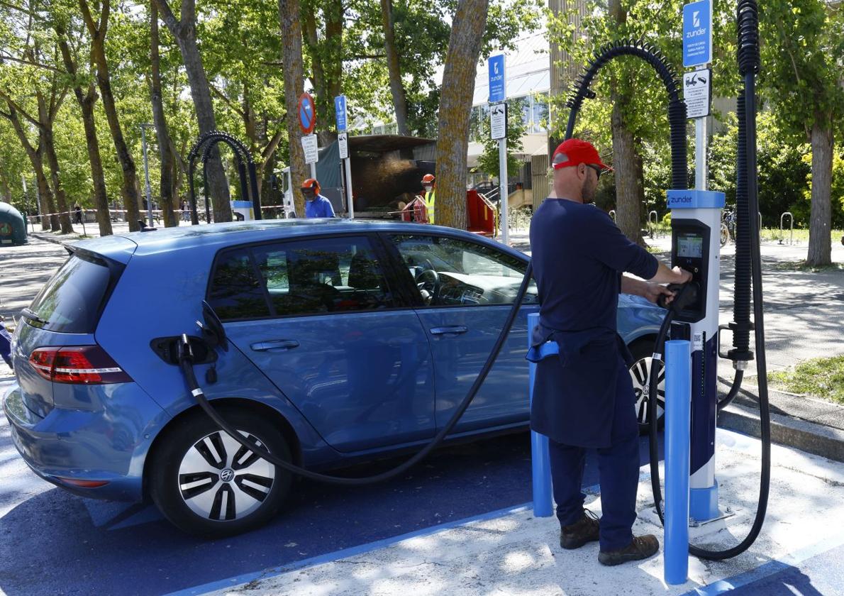 Un conductor cargando un vehículo eléctrico.