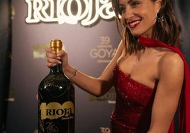 La actriz Hiba Abouk posa con la botella.