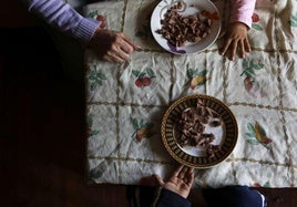 Una madre en situación de vulnerabilidad pone la comida a sus hijos.