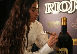 Carolina Yuste firma una de las botellas de Rioja.