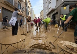 Voluntarios limpian una calle de Benetússer, pocos días después de la dana.