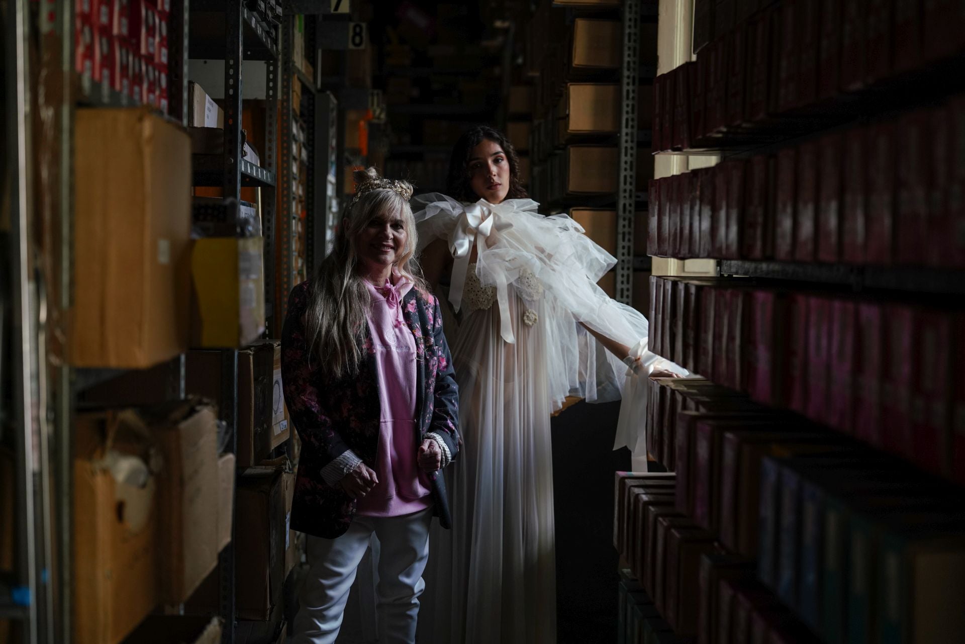 La diseñadora María Lafuente posa con una modelo con uno de sus diseños entre las estanterías de la zona de almacenaje en la planta de arriba de la tienda. La asturiana es una de las clientas habituales de los comercios centenarios de Madrid. 