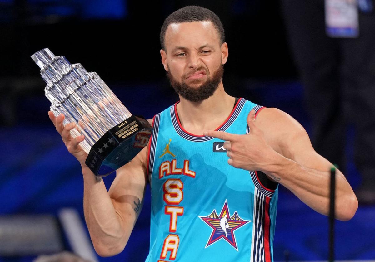 Stephen Curry levanta el trofeo que acredita al equipo de Shaquille O'Neal como ganador del All-Star.