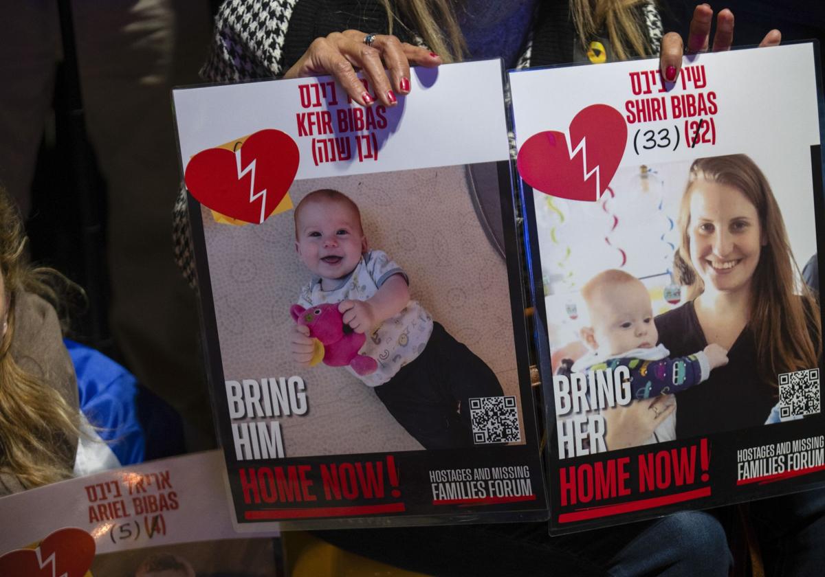 Un manifestante sujeta carteles con la imagen de Shiri Bibas y sus hijos Ariel y Kfir.