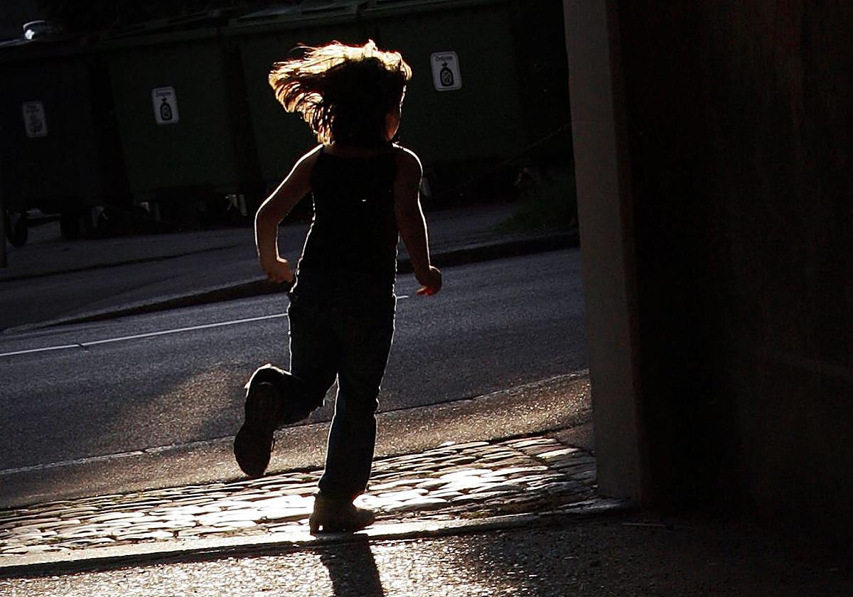 La silueta de una niña mietras corre.