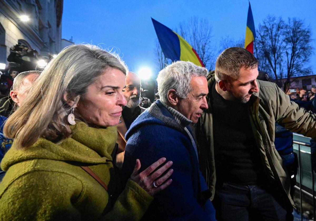 El candidato presidencial Calin Georgescu y su esposa salen de la sede de la Fiscalía General en Bucarest.