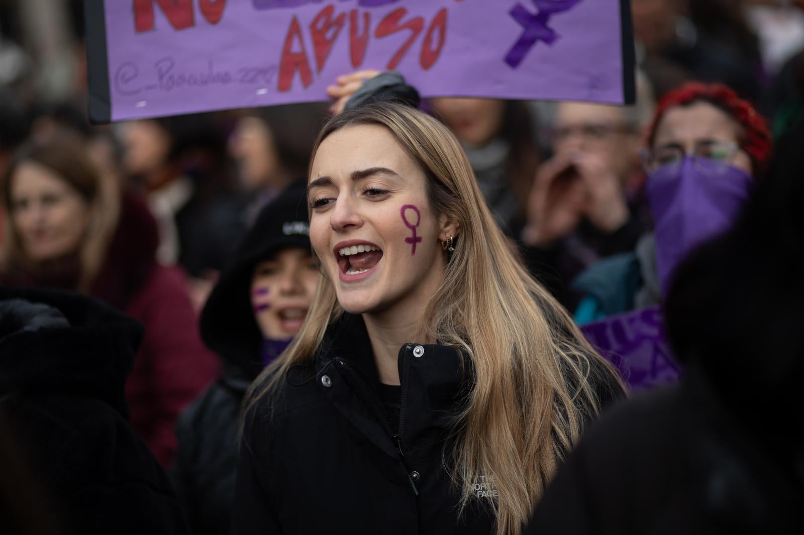 Una joven con el símbolo de la mujer pintado en la cara