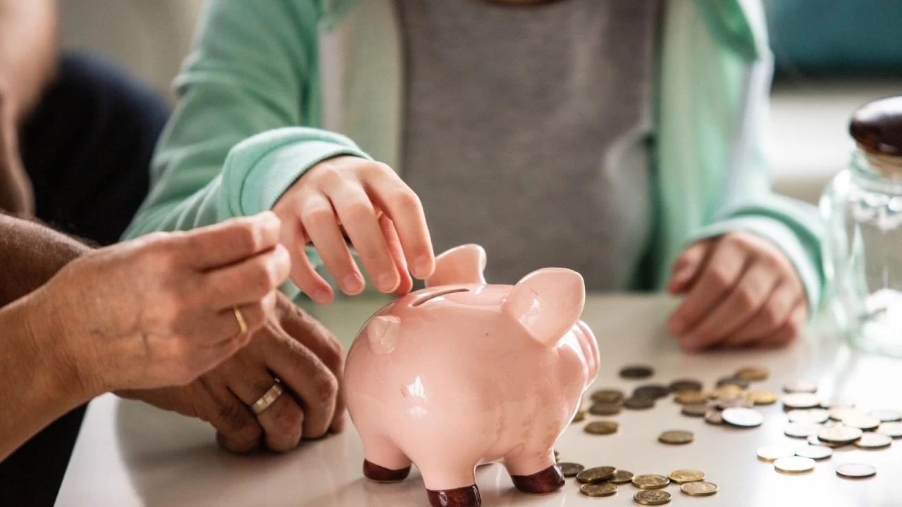 Familia llena una hucha con monedas.