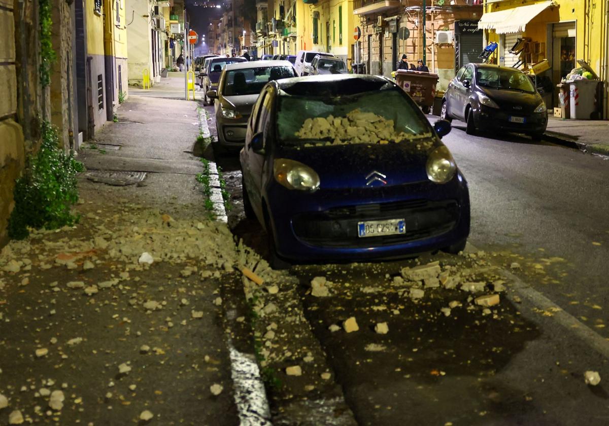 Un automóvil dañado en la calle después de que un terremoto nocturno sacudiera Nápoles, Italia.