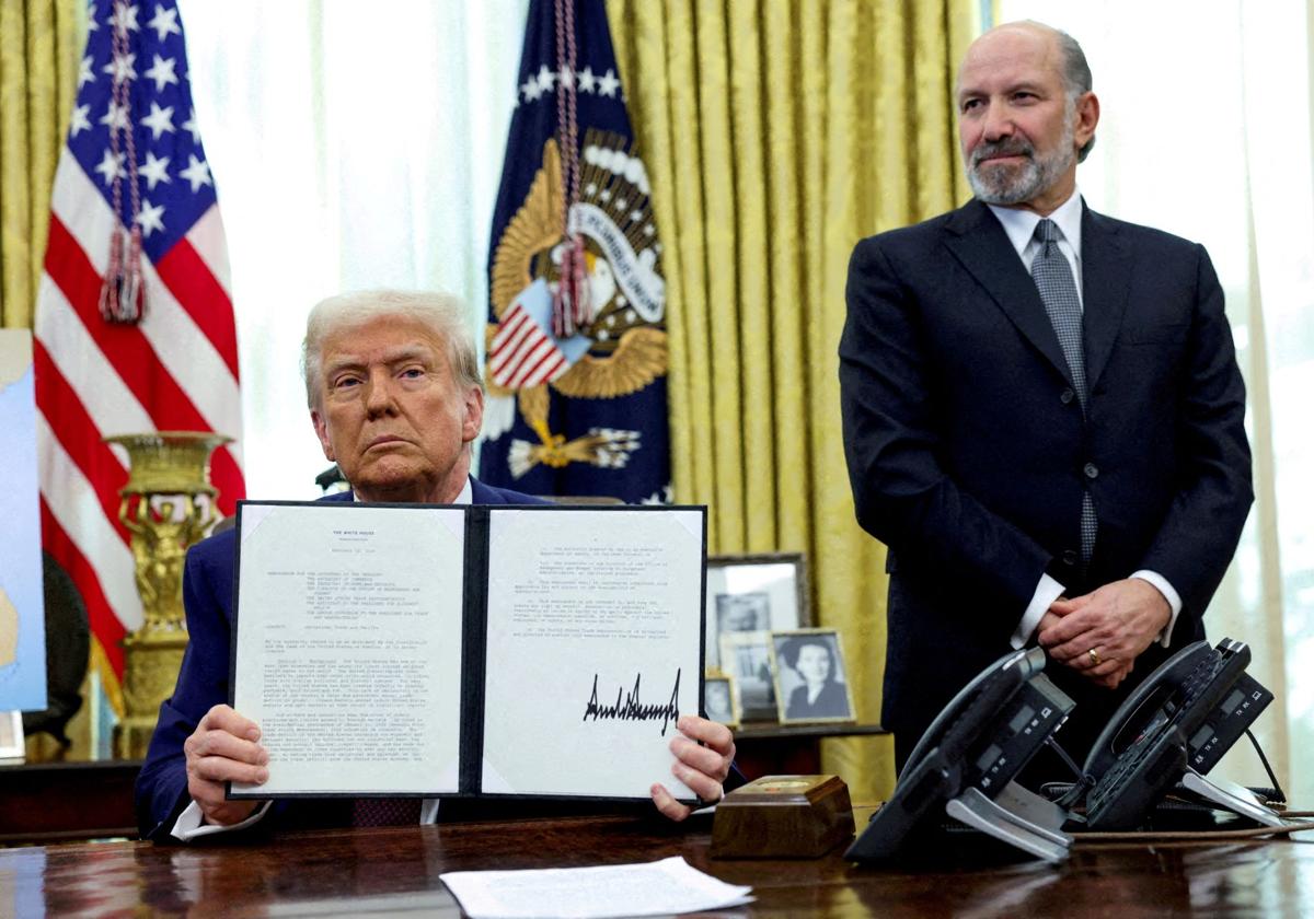 Trump firma una orden ejecutiva bajo la mirada del secretario de Comercio, Howard Lutnick.