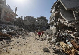 Palestinos caminan entre los edificios en ruinas en Yabalia, en el norte de Gaza.