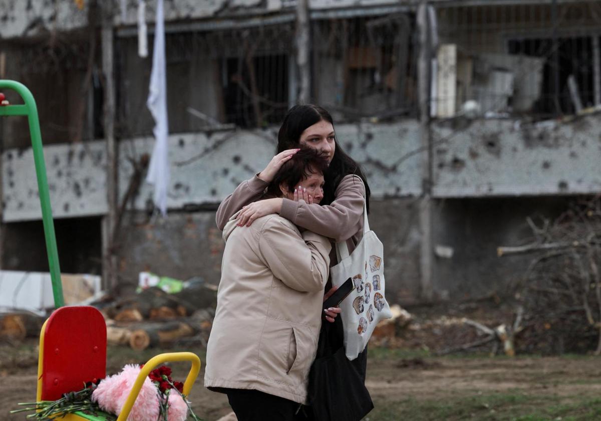 Dos mujeres junto al lugar en el que un ataque ruso dejó varios niños muertos en la ciudad ucraniana de Krivói Rog.