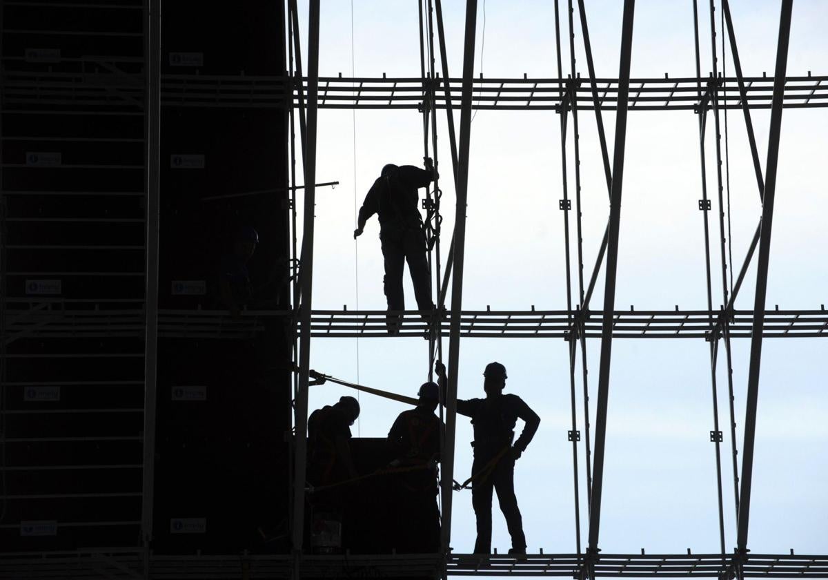 Varios trabajadores de la construcción, en un andamio.