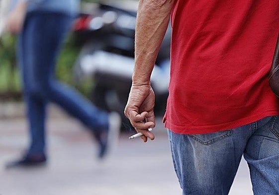 Peatón, con un cigarrillo encendido