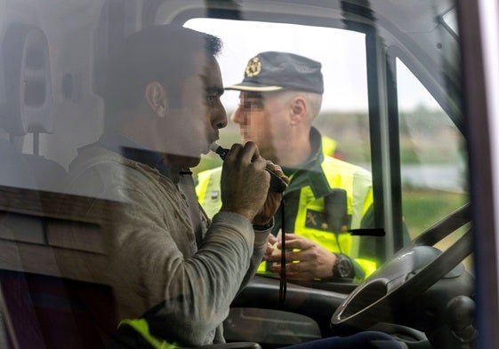 Un conductor sopla el etilómetro durante un control de la Guardia Civil.