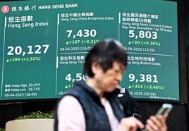 Un inversor consulta las cotizaciones de precios en el parqué de Hong Kong