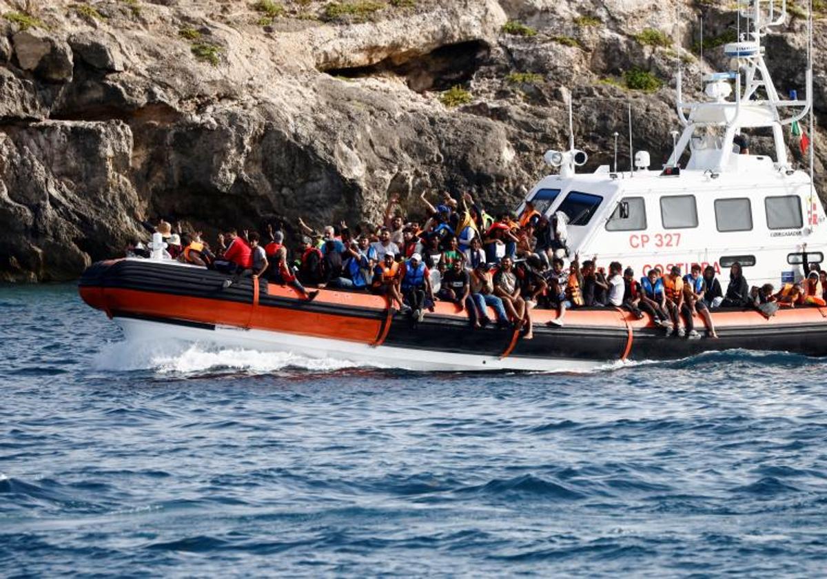 Un barco de la Guardia Costera italiana traslada al puerto de Lampedusa a un grupo de migrantes rescatados en el Mediterráneo.