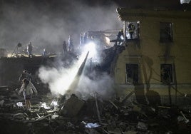 Los equipos de rescate buscan víctimas entre los escombros tras el ataque ruso de este jueves en Kiev.