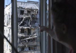 Una mujer muestra los daños de un edificio vecino bombardeado por el ejército ruso en Zaporiyia.