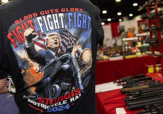Un hombre con una camiseta de Trump en una armería.
