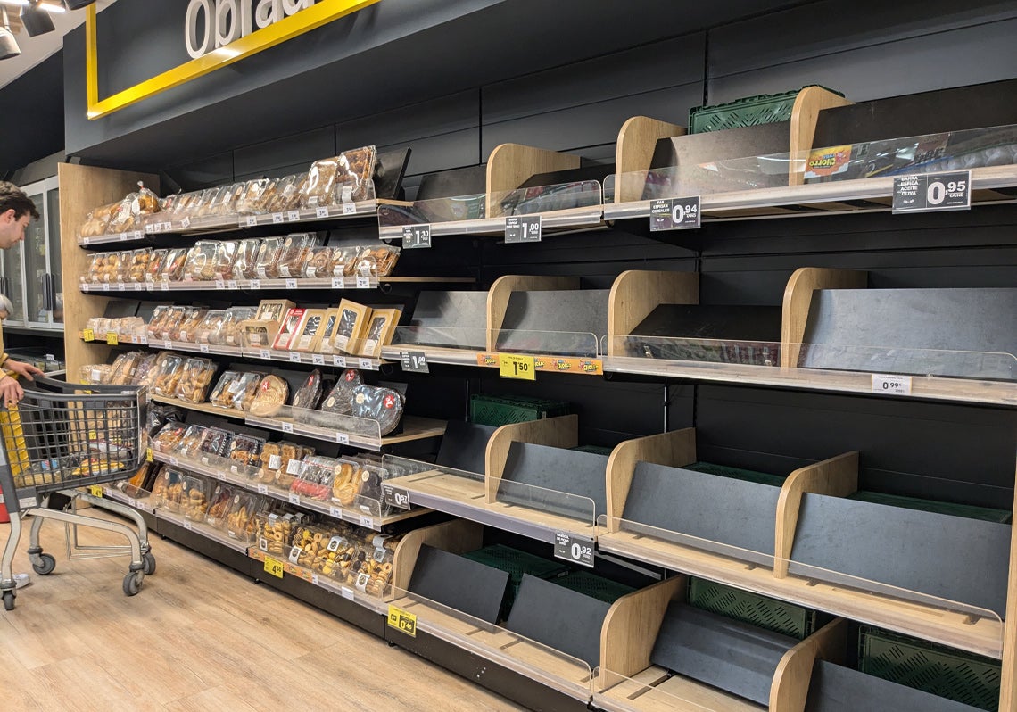 Los estantes de pan de un supermercado, completamente vacíos.