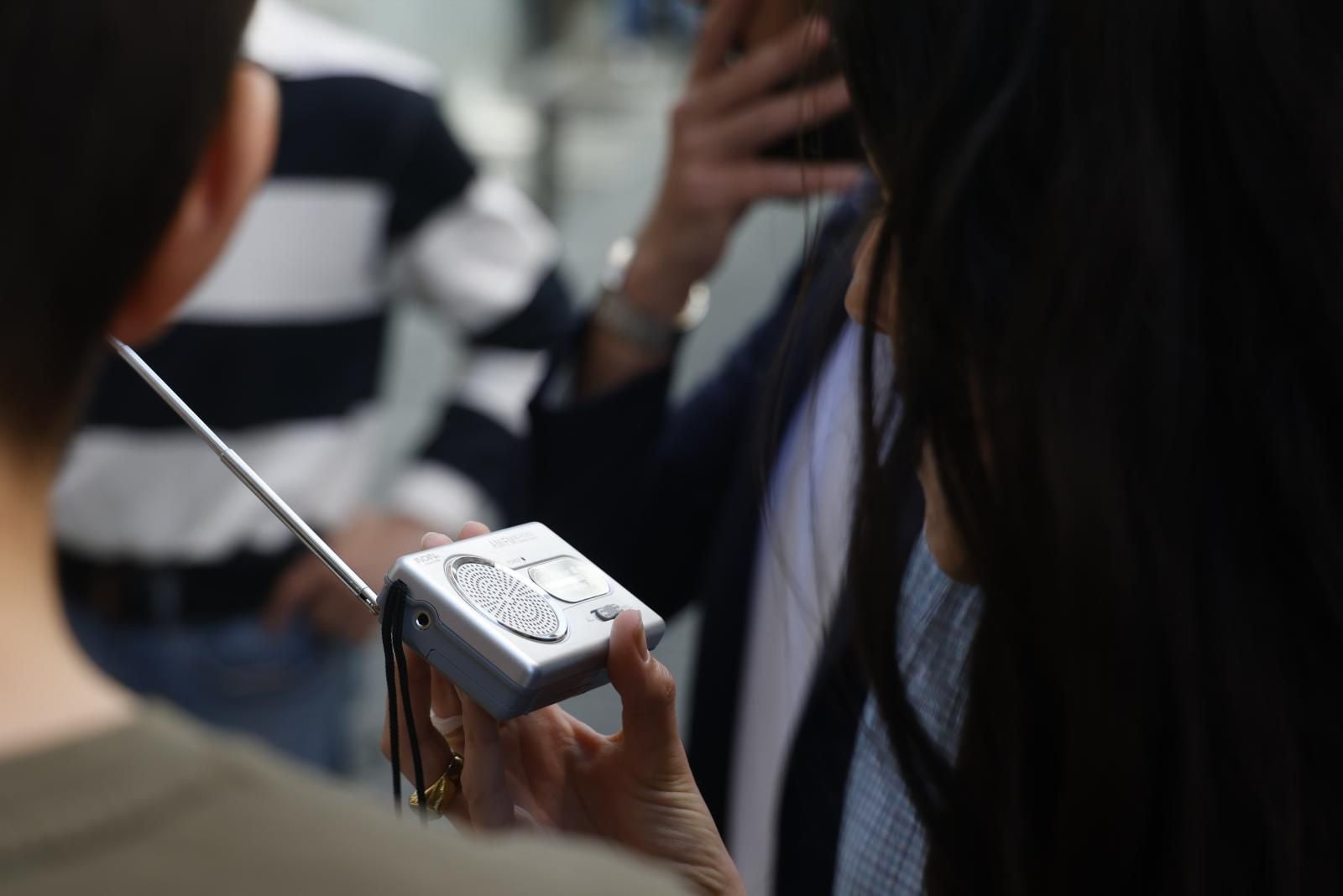 Una mujer escucha una radio inalámbrica para conocer los últimos detalles sobre el apagón