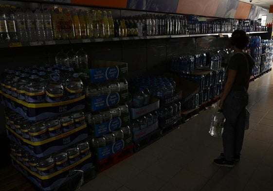 Una mujer en un pasillo apagado de un supermercado