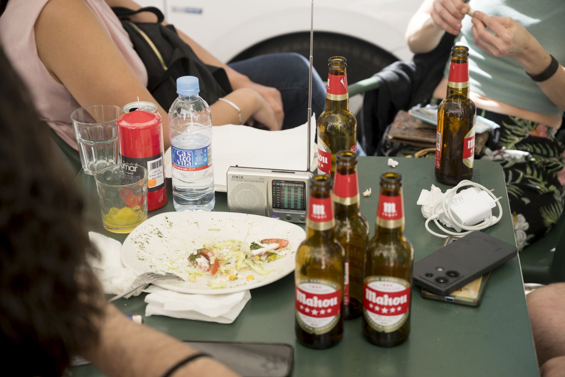 Un grupo de amigos toman algo mientras escuchan la radio en una terraza.