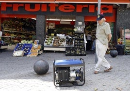 Un hombre mira un generador eléctrico en la calle