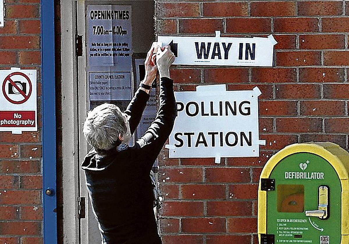Un hombre señala la entrada al colegio electoral en Cambridge.