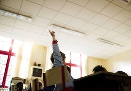 Un niño levanta el brazo para participar durante una clase.