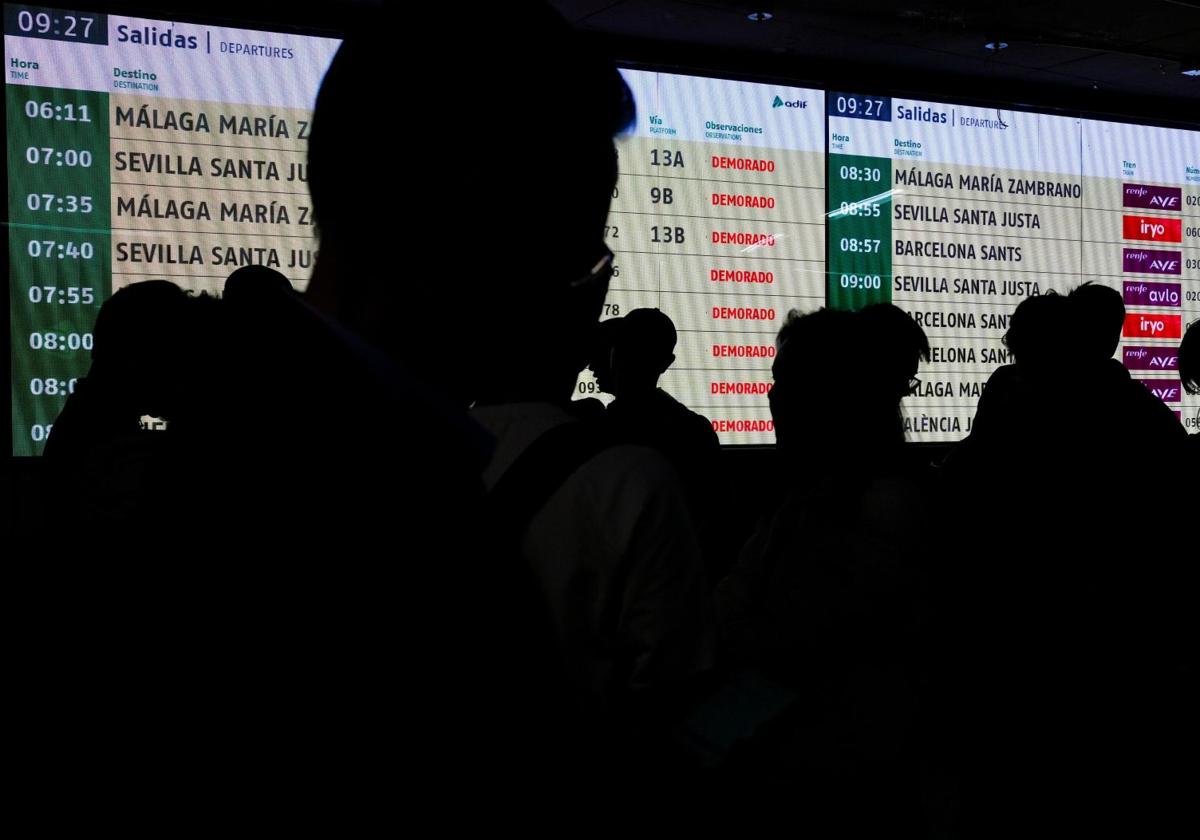 Pasajeros frente al panel de llegadas de la estación de Atocha.