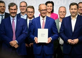 El líder de la CDU y próximo canciller alemán, Friedrich Merz, el copresidente del SPD, Lars Klingbeil y el líder de la CSU, Markus Söder, posan con el acuerdo de coalición.