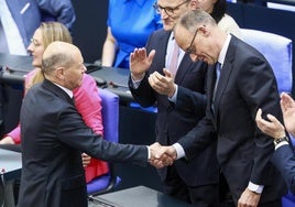 El socialdemócrata Olaf Scholz (izquierda) felicita a su sucesor al frente de la cancillería, el conservador Friedrich Merz, tras su investidura ayer en el Bundestag.