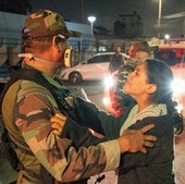 Una mujer habla con un Policía frente a la morgue a la que fueron trasladados los cuerpos de los 13 mineros peruanos asesinados.