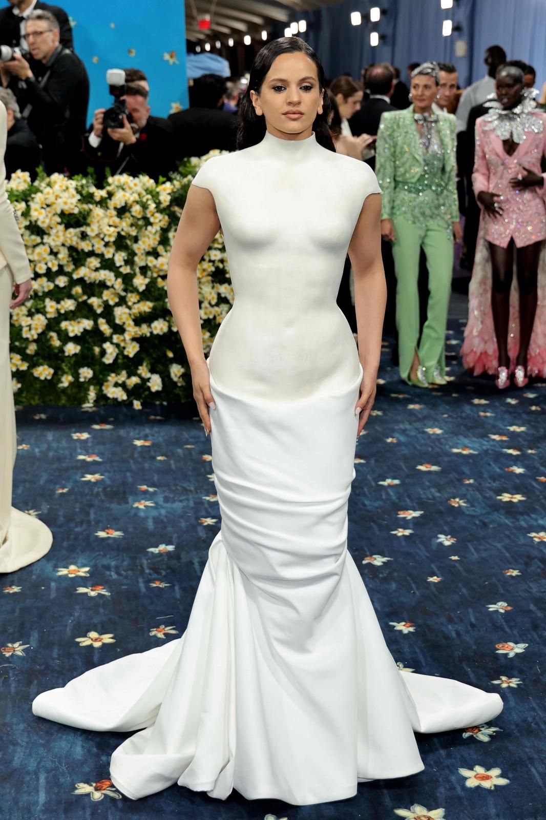 Rosalía, muy favorecida aunque pasando de la temática de este año de la gala del MET, dandismo negro, ha escogido al director creativo de Balmain, Olivier Rousteing, para el evento. La cantante llevó un original vestido con parte superior rígida a modo de escultura griega y falda drapeada en un interesante juego de texturas.