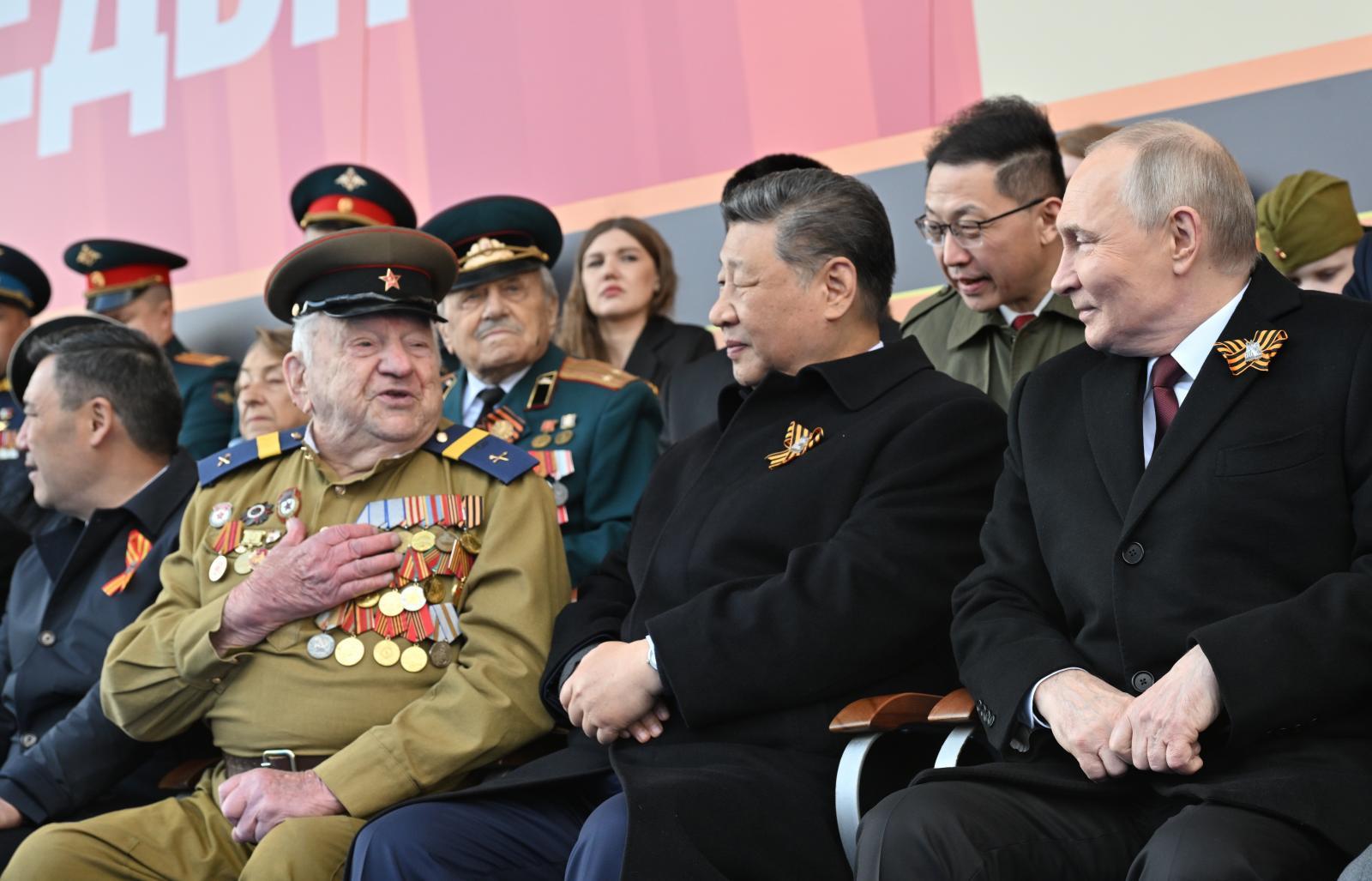Putin y Xi Jinping escuchan a un veterano de guerra.