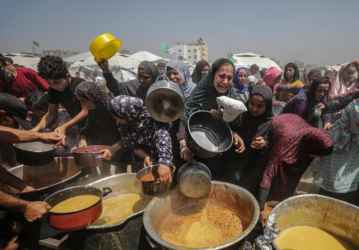 Familias palestinas desplazadas intentan conseguir una ración de comida en el campo de refugiados de Yabalia, en el norte de Gaza.
