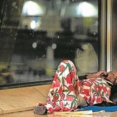 Un hombre que usa la T4 para pernoctar habla por el móvil.
