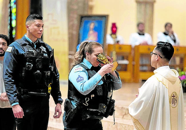 Oficiales de Policía comulgan en una misa en honor de León XIV en la catedral de Chicago.