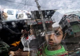 Una niña mira por la ventana de un coche mientras regresa a su ciudad natal después del alto el fuego entre India y Pakistán.
