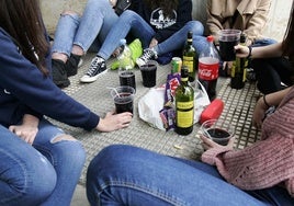 Un grupo de jóvenes participan en un botellón en la calle.