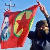 Una persona ondea una bandera con el retrato del fundador del PKK.
