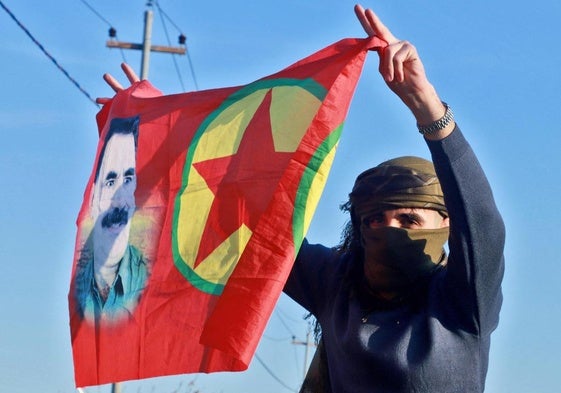 Una persona ondea una bandera con el retrato del fundador del PKK.