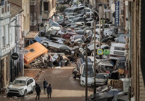 Vehículos amontonados en una calle tras las intensas lluvias de la fuerte dana en Alfafar, Valencia.